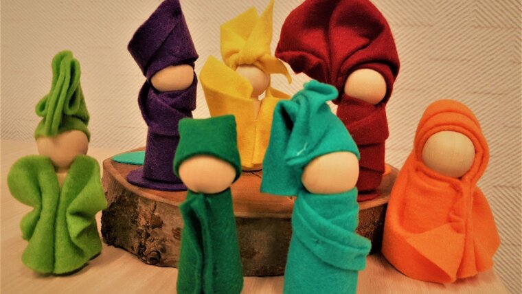 Seven wooden figurine in mixed colored dresses