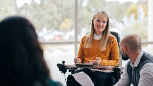 Studentin im Rollstuhl spricht in Seminargruppe