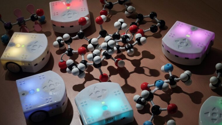 Illuminated robots next to molecule models