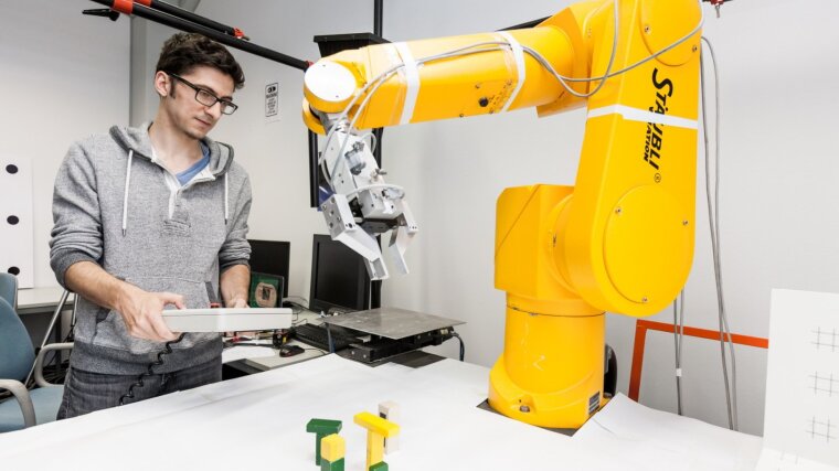 Student steuert einen Roboterarm
