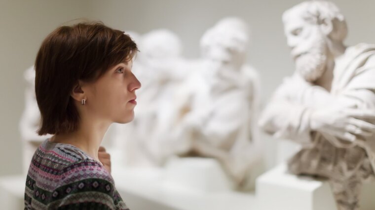 Studentin betrachtet Skulpturen