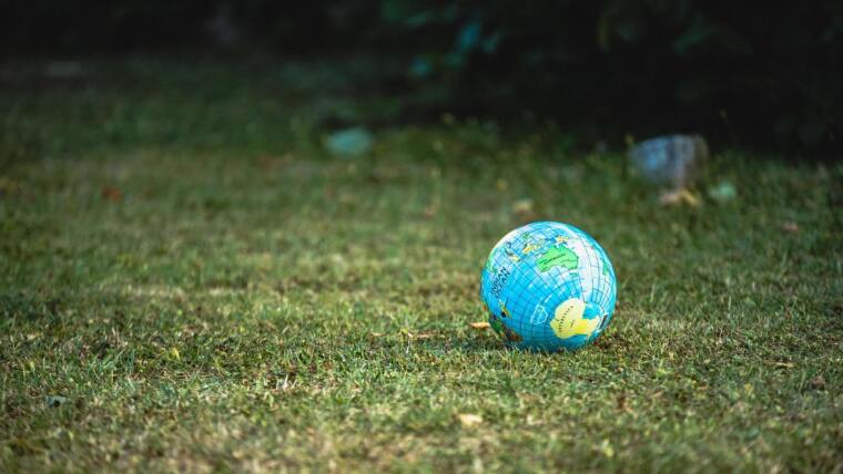 Ein Globus liegt auf einer Grasfläche.