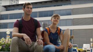 Platzhalterbild — Zwei Studierenden sitzen auf dem Campus.
