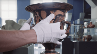 Platzhalterbild — Behandschuhte Hände halten eine Antike Vase.