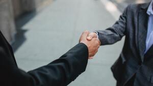 People in suit shake hands