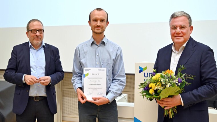 Robert Spalthoff (M.) erhält von Thomas Kamradt (l.) und Michael Kiehntopf den Promotionspreis.