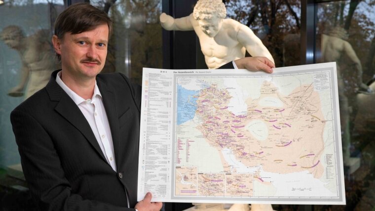 Dr. Frank Schleicher mit einer Landkarte des sasanidischen Iran.