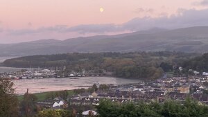 view of Bangor, the Irish Sea, and Eryri with pink clouds and moon