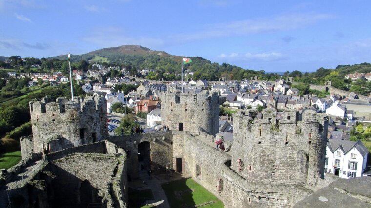 Conwy Castle in front of blue skies and green hills