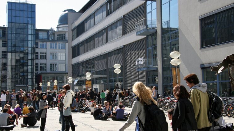 Studierende, die über den Campus der Uni Jena laufen