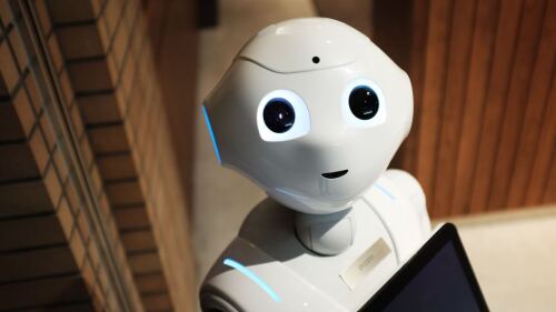 Ein Roboter mit freundlichen Gesicht schaut den Betrachter an.