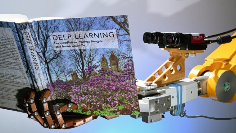 Ein Roboter am Lehrstuhl für Digitale Bildverarbeitung an der Fakultät für Mathematik und Informatik der Universität hält ein Buch in der künstlichen Hand (Foto vom 16.07.2019). Mit seinen zwei Kameraaugen scheint er das Sachbuch "Deep Learning" von Ian Goodfellow, Yoshua Bengio und Aaron Courville zu lesen.