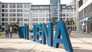 Große blaue Buchstaben bilden den Namen "Uni Jena" auf dem Campus Ernst-Abbe-Platz.