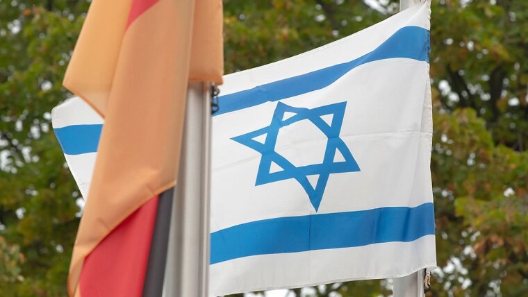 The Israeli flag, right, flies next to the German flag.