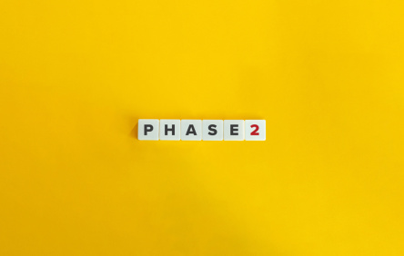 Phase 2-Buchstabenwürfel auf gelbem Hintergrund