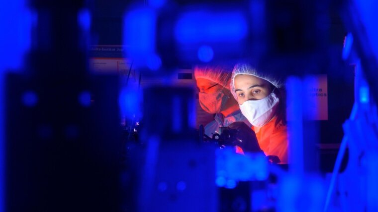 Female scientist in a laser laboratory. Female researchers, graduates and students interested in founding a company can apply for a scholarship as part of the EXIST Women programme.
