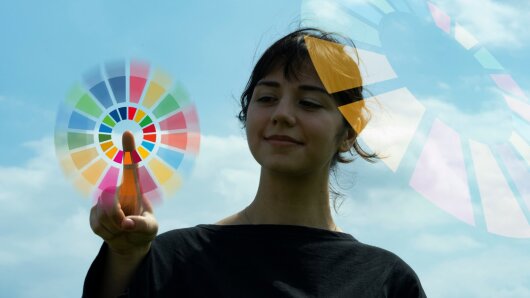 A young woman taps her finger in a colored circle