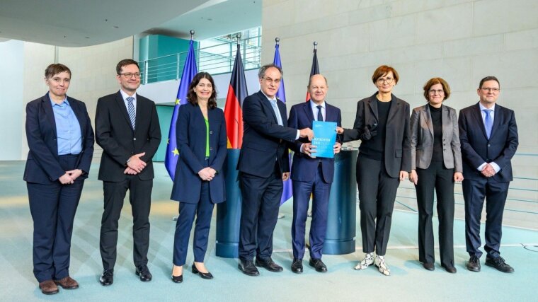 EFI Chairman Uwe Cantner (4.f.l.) presents the report to Federal Chancellor Olaf Scholz (4.f.r.).