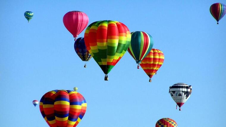 Bright blue sky with lots of colorful hot air balloons