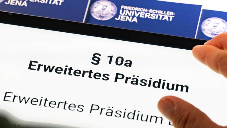 Eine Hand liegt auf einem Tablet, dass die Überschrift "§ 10a Erweitertes Präsidium" der Grundordnung der Uni Jena zeigt.