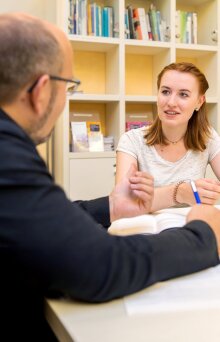 Ein Mitarbeiter der Uni Jena berät eine junge Studentin.