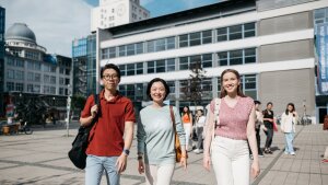 Drei Studierende laufen über den Ernst-Abbe-Campus in Jena