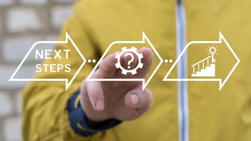 Eine Hand tippt auf einen Screen, auf dem "Next steps" steht