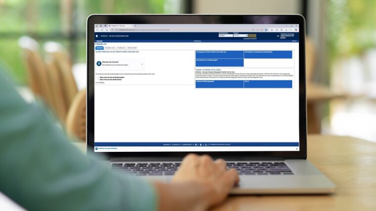 Eine Person sitzt vor einem Laptop und auf dem Bildschirm ist das Bewerbungsportal Friedolin 2.0 abgebildet.