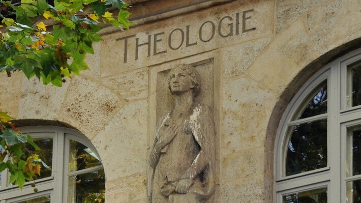 Foto: Steinmetzfigur für die Fakultät der Theologie am Fenstersims, UHG