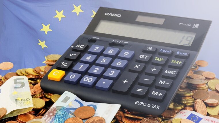 Calculator on coins in front of EU flag