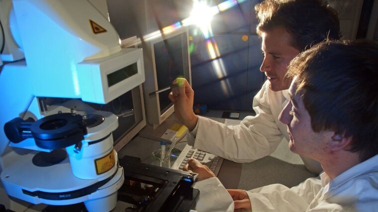 Zwei Mikrobiologen arbeiten an einem Flureszenzmikroskop